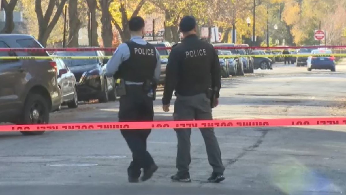 officers walking past crime scene tape