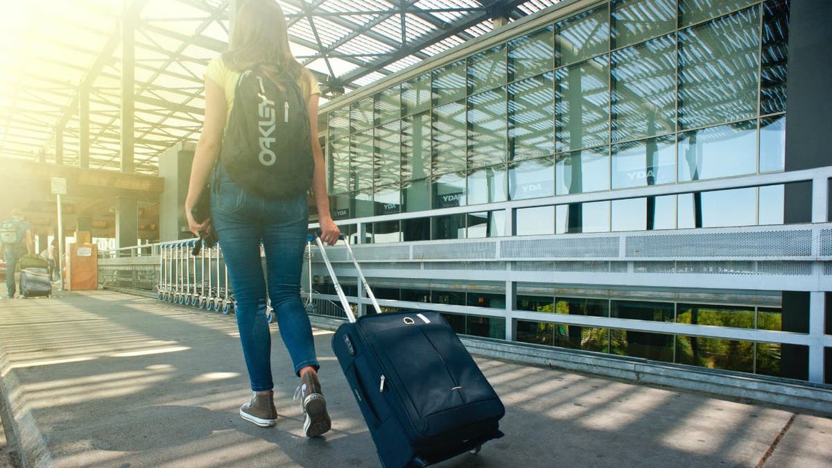 Girl traveling with suitcase through airport