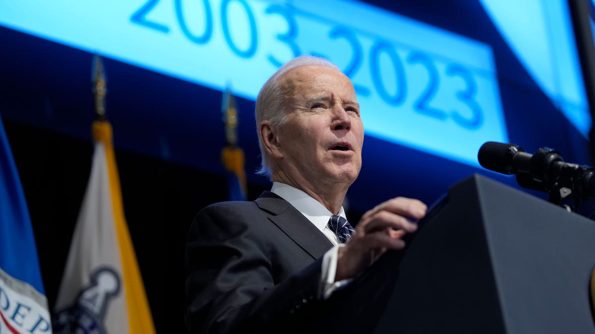 President Joe Biden speaks in front of podium