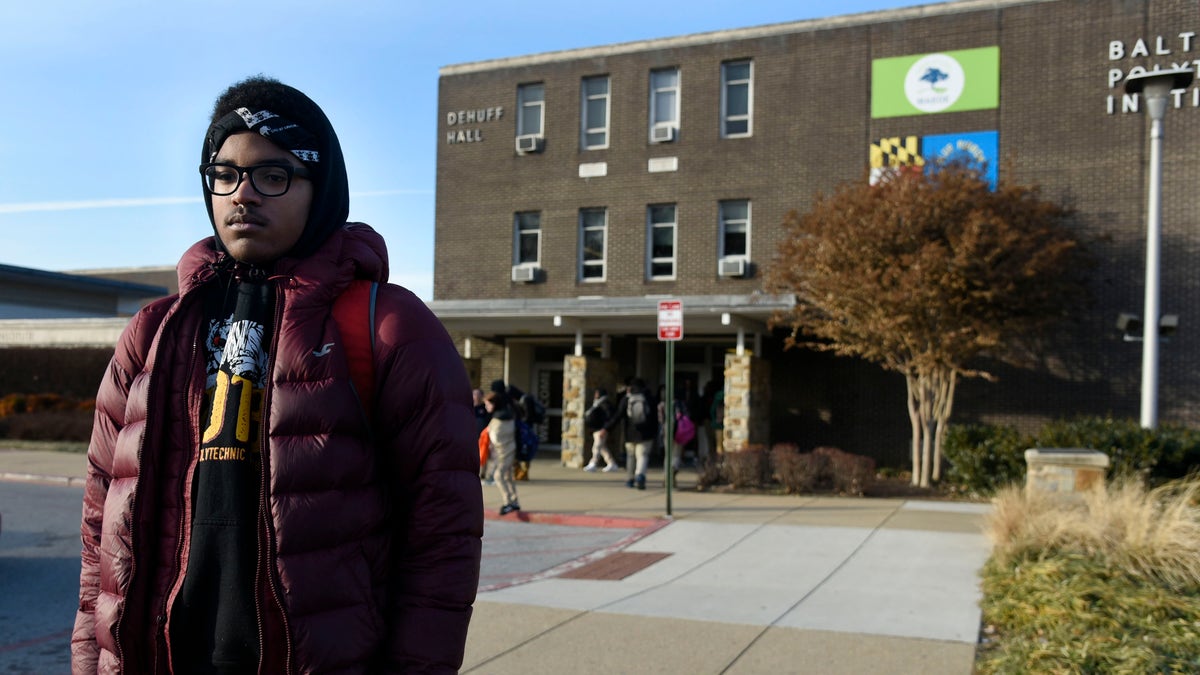 Student stands outside of a Baltimore City high school