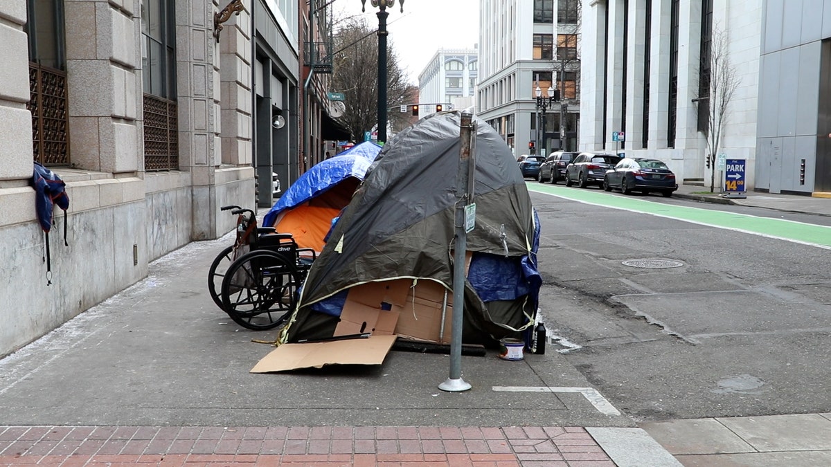 Tents and a wheelchair cover a sidewalk in downtown Portland