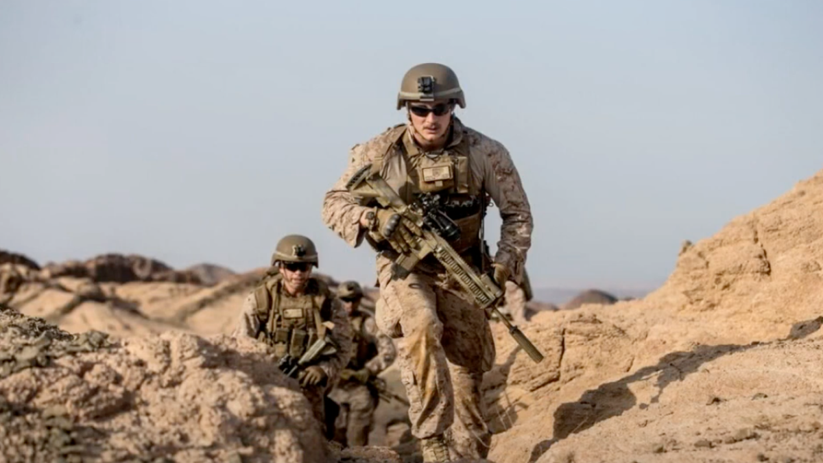 Cpl. Daegan Page in full fatigues running up a hill with a rifle