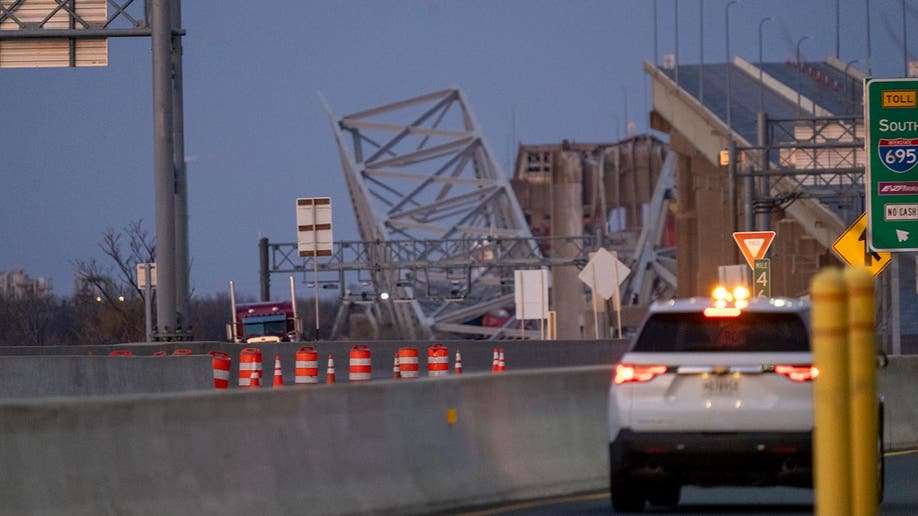 Baltimore bridge collapsed in the background as emergency vehicles are seen in the foreground