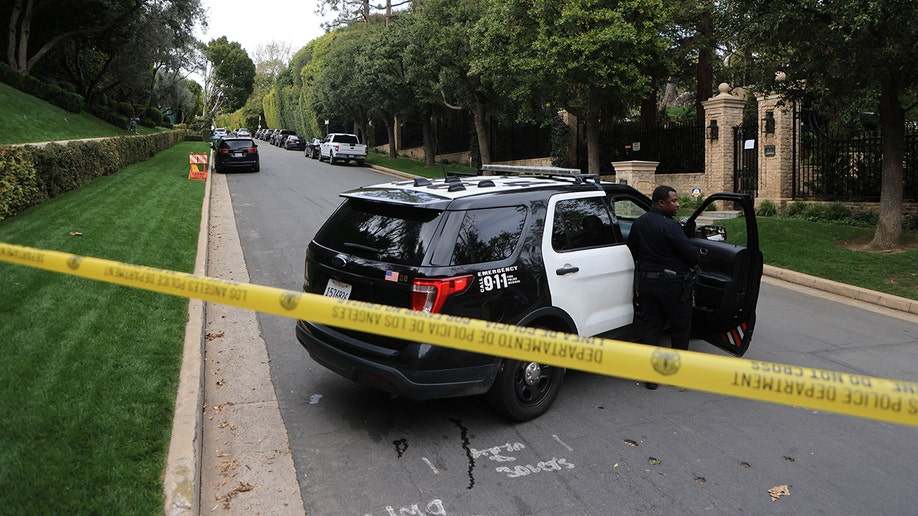 Police car with yellow tape behind it outside Diddy's property