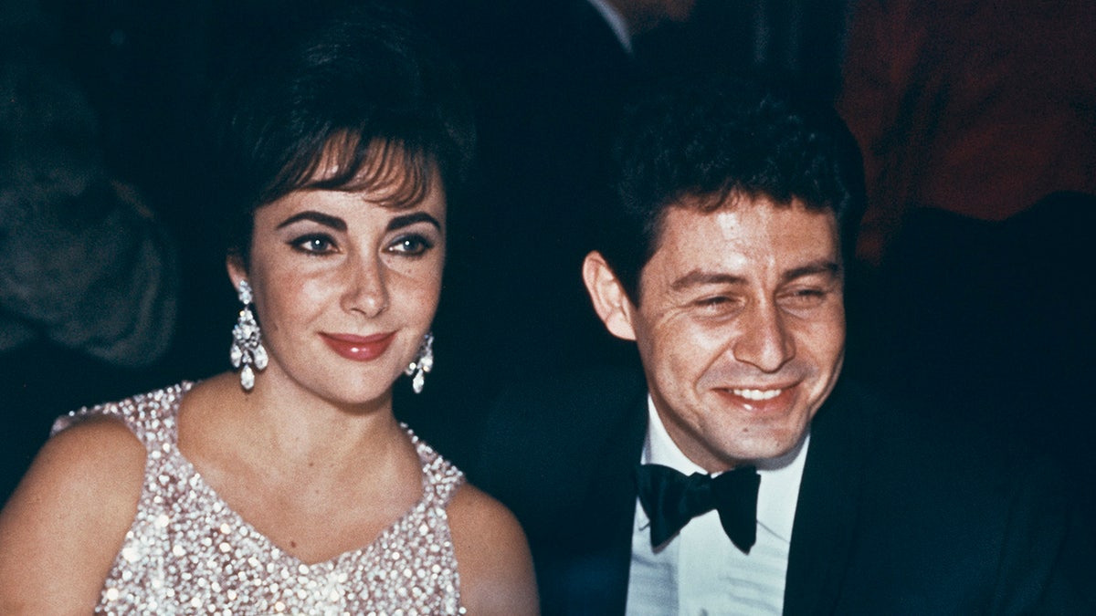 A close-up of Elizabeth Taylor and Eddie Fisher smiling at a gala.