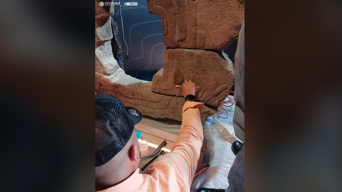 Man cleaning ancient mask