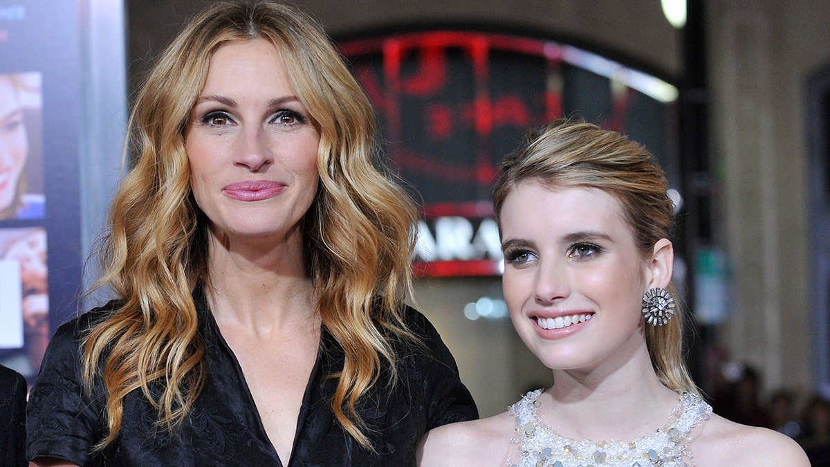 Julia Roberts soft smiles on the carpet with niece Emma Roberts in a white dress