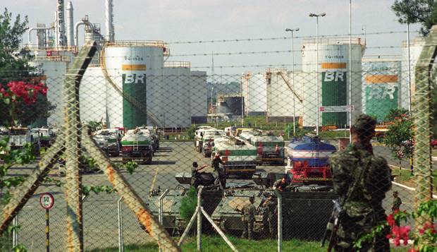 Cenário de guerra. Soldados estacionam os blindados do Exército próximo aos caminhões-tanque na Replan, em Paulínia (SP)