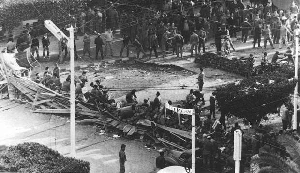 Início da guerra. Pessoas observam destruição provocada pela explosão de uma bomba da Frente de Libertação Nacional da Argélia