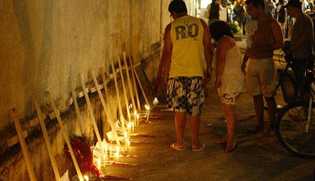 Luto. Na fachada da Tasso da Silveira, velas e flores para lembrar os jovens mortos