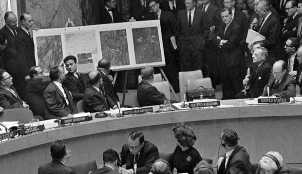 O embaixador dos EUA na ONU, Adlai Stevenson, à direita, mostra ao Conselho de Segurança fotografias aéreas das bases de mísseis soviéticos em Cuba