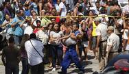 Massacre. Uma aluna da Escola Municipal Tasso da Silveira é carregada após o massacre que deixou 13 mortos