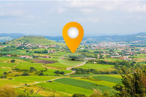 a map pin over a green landscape