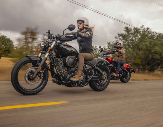 2 Men riding motorcycles down the road