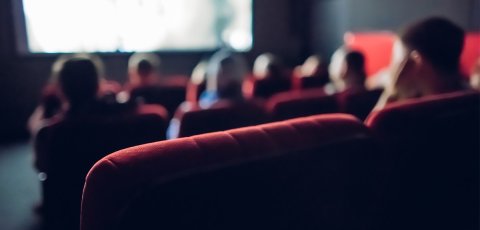 Small movie theater background. Audience in the dark