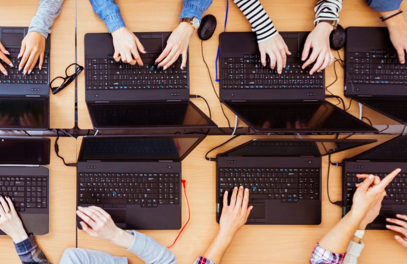 mirror image of people typing on black laptop computers