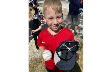 Calvin Moehrle, an 8-year-old from Minneapolis, showed off his autographed Twins cap and Royce Lewis-signed ball outside Hammond Stadium in Fort Myers