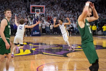 Elijah Hazekamp (12) and Kyreese Willingham (1) celebrate after Hazekamp's buzzer-beater on Tuesday, which sent the Mavericks to the Elite Eight.