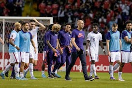 United States' coach Gregg Berhalter, center, and his team's players leave the pitch after losing 2-0 to Costa Rica yet still qualifying for the World