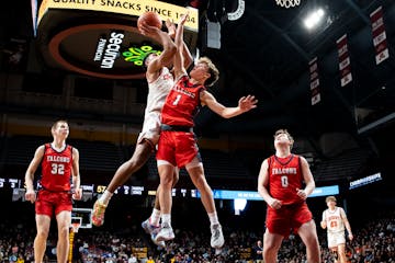 Cherry's Isaac Asuma, second from left, defended by Fertile-Beltrami's Bryer Strem (1), makes a shot during the Class 1A boys basketball championship 