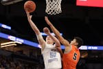 Russell-Tyler-Ruthton's Drew Werkman (50) lays the ball up beyond the reach of Noah Asuma (5). Werkman finished with 16 points in the Knights' 61-57 s