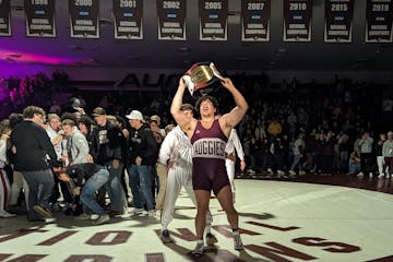 Tyler Kim holds up the "Swens-Milboy Belt," awarded to the winner of the Augsburg-Wartburg men's wrestling dual meet, after his win at 285 pounds clin