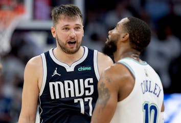 Mavericks guard Luka Doncic talks with Wolves guard Mike Conley in the fourth quarter of Game 1 of the Western Conference finals at Target Center.