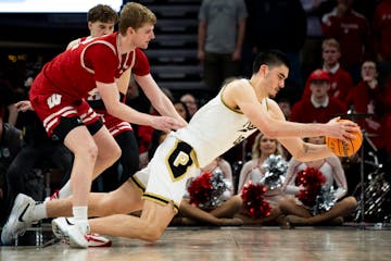 Purdue center Zach Edey falls to the floor as he's defended by Wisconsin's Steven Crowl on Saturday.