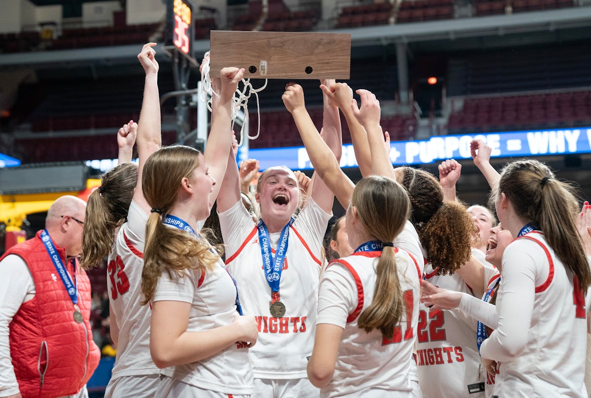 Benilde-St. Margaret's Olivia Olson hefts the Class 3A basketball hardware after the Red Knights won the championship.