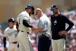 The Twins' Carlos Correa is looked at by team trainer Nick Paparesta after Correa was hit by a pitch during the first inning against the Houston Astro