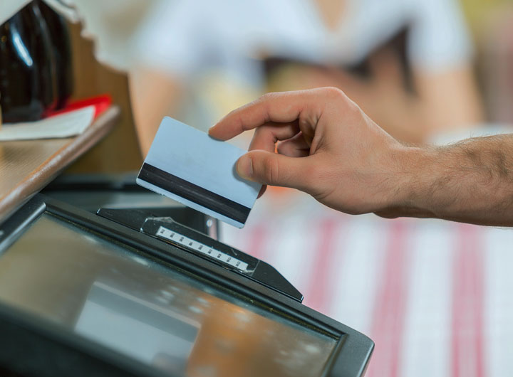 Image of person swiping a credit card