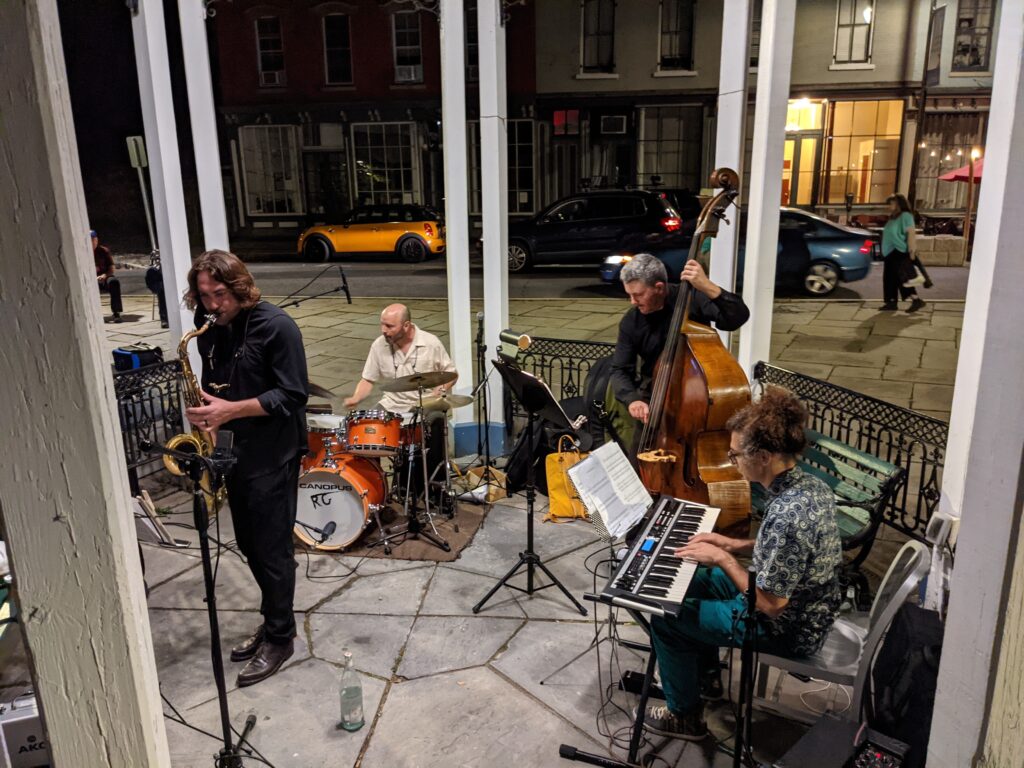 A jazz quarter performs in an outdoor pergola