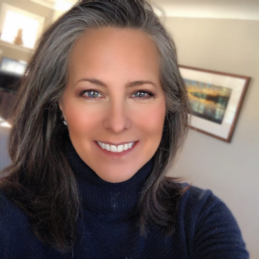 Headshot of a person with medium light skin tone, dark hair, and a black turtleneck sweater.