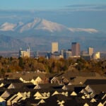 Roofs of houses in the foreground, Rocky Mountains in the background