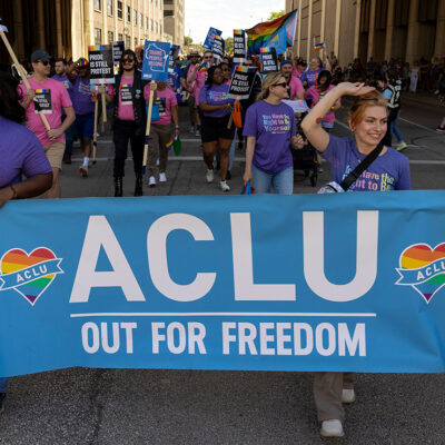 Two demonstrators holding a sign that says "ACLU Out For Freedom."