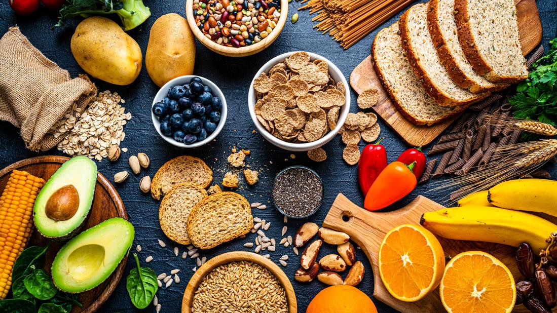 Assorted healthy foods spread out over a table and cutting boards