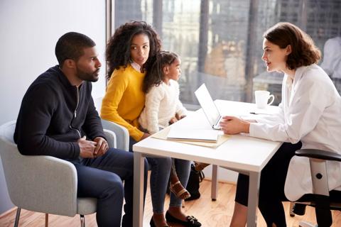 Mother, father and child meeting with doctor in medical office