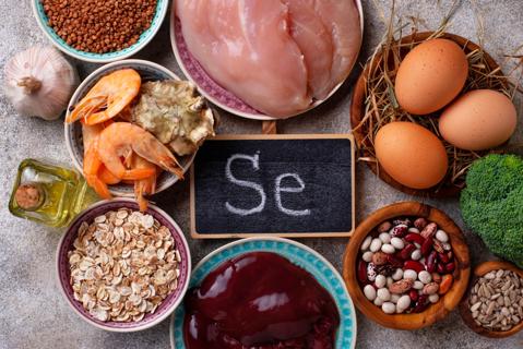 Assorted foods with selenium on plates and in bowls, with chalkboard with SE on it