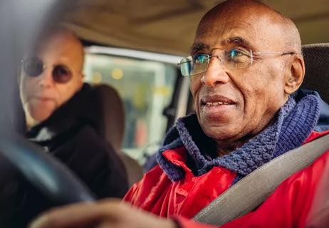 elderly man driving a vehicle