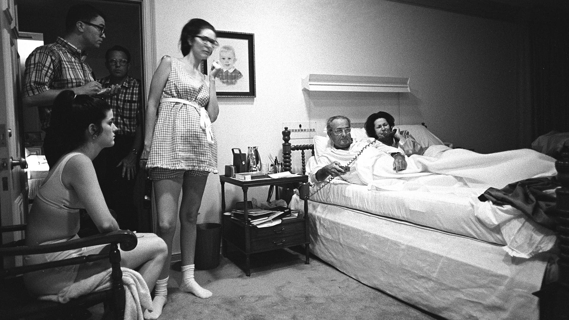 The Johnson family watches coverage of protests at the Democratic Convention on August 28 1968. Shown are, (L-R) Luci Johnson Nugent, Tom Johnson, unidentified, Lynda Johnson Robb; in bed: President Lyndon B. Johnson, Lady Bird Johnson.