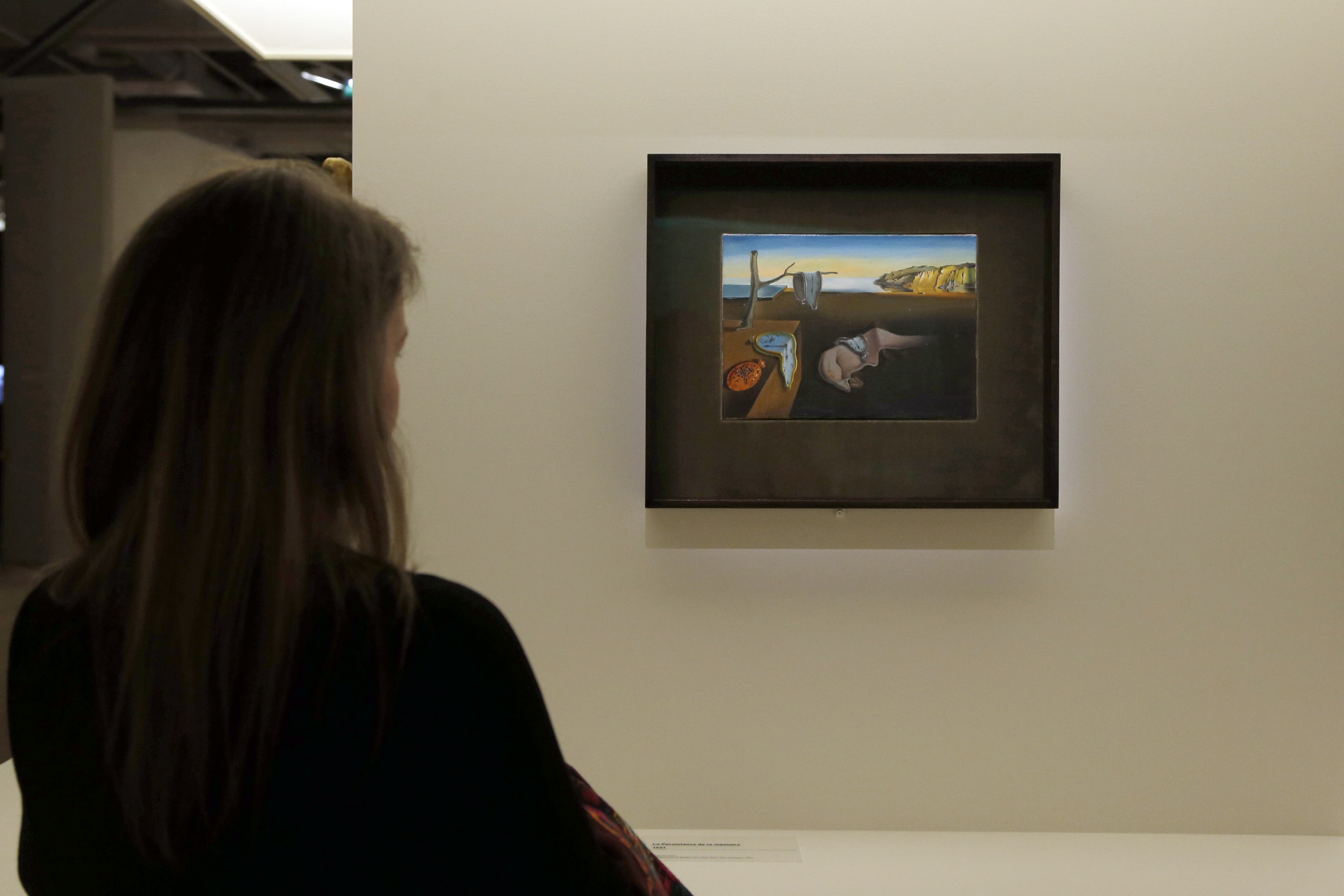 A visitor looks at a painting entitled "La persistance de la mémoire" (Persistence of Memory) by Spanish surrealist artist Salvador Dali's during an exhibition devoted to his work at the Centre Pompidou contopary art center (aka Beaubourg) on November 19, 2012 in Paris. More than 30 years after the first retrospective in 1979, the event gathers more than 200 art pieces and runs until March 13, 2013. AFP PHOTO FRANCOIS GUILLOT (Photo credit should read FRANCOIS GUILLOT/AFP via Getty Images)