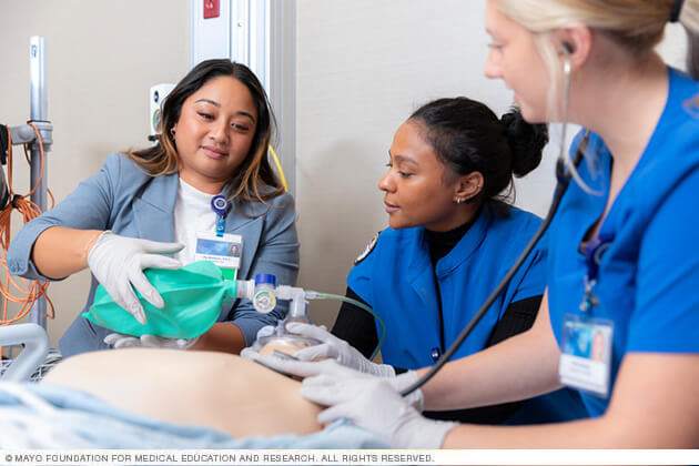 A Mayo Clinic medical instructor demonstrates a technique on a medical mannequin.