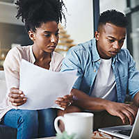 Couple reviewing paperwork in their home.