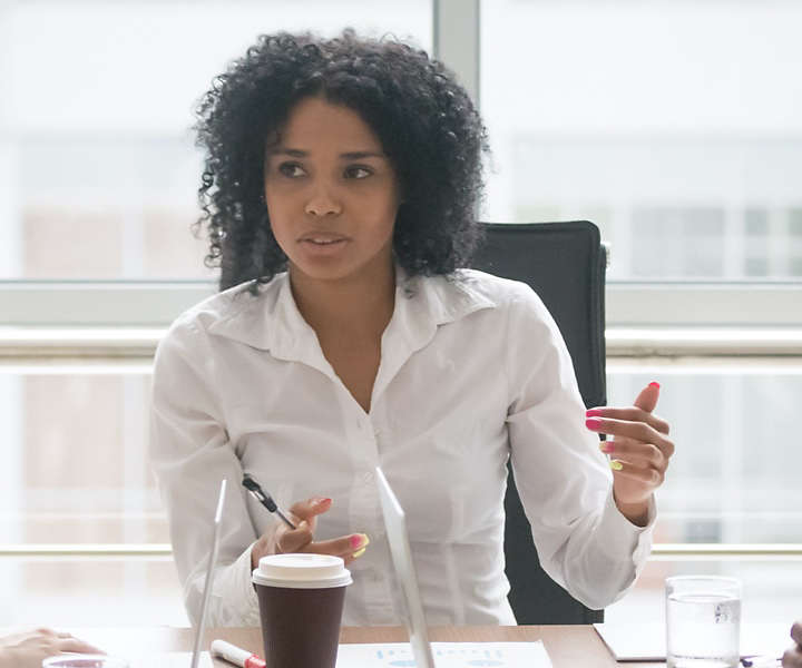 Person presenting notes at conference table