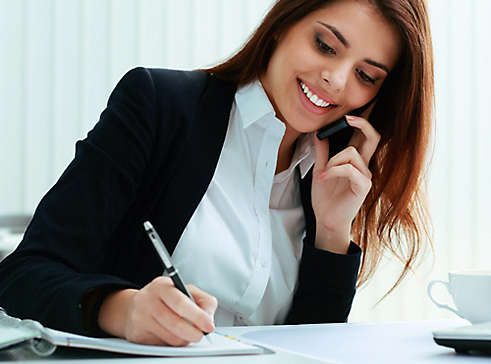 Person on the phone while writing in notebook.