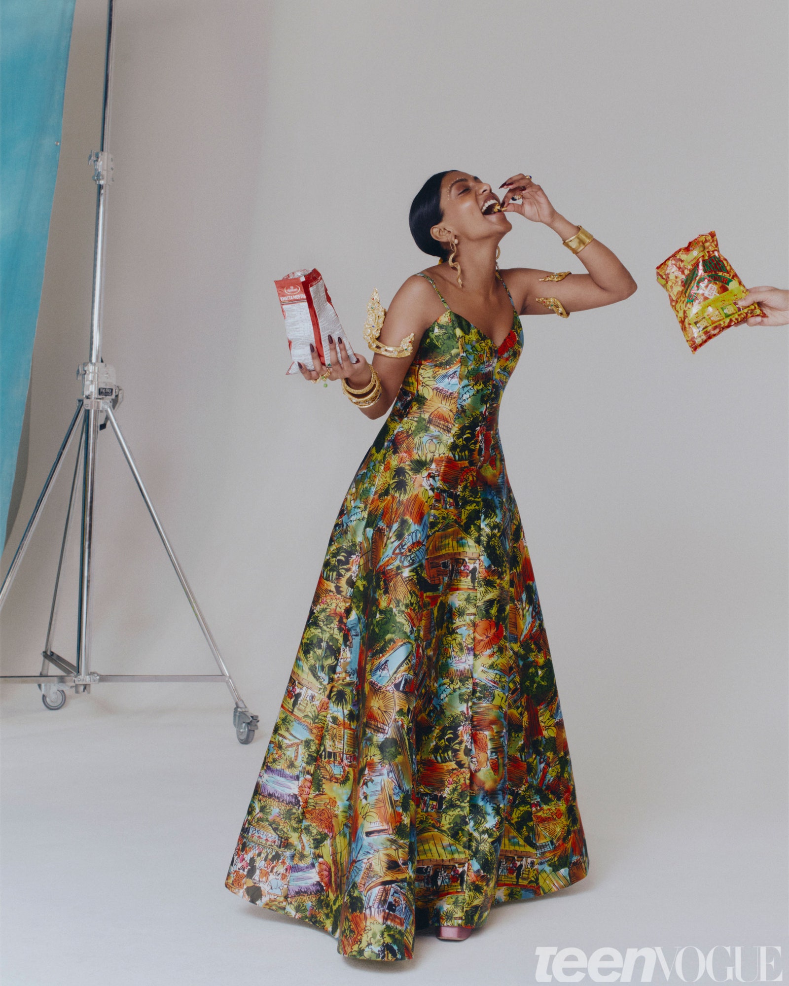 Charithra Chandran wearing the same colorful dress and armbands she dons on the cover looking joyful as she eats Indian...