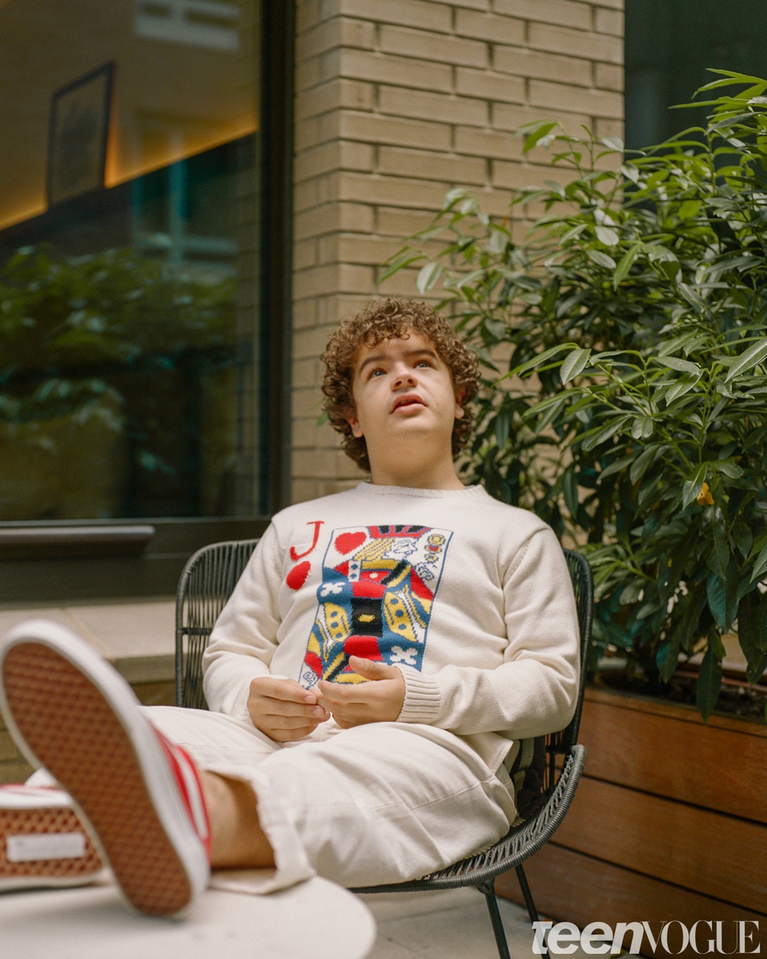 Gaten Matarazzo sitting on a chair with his feet up