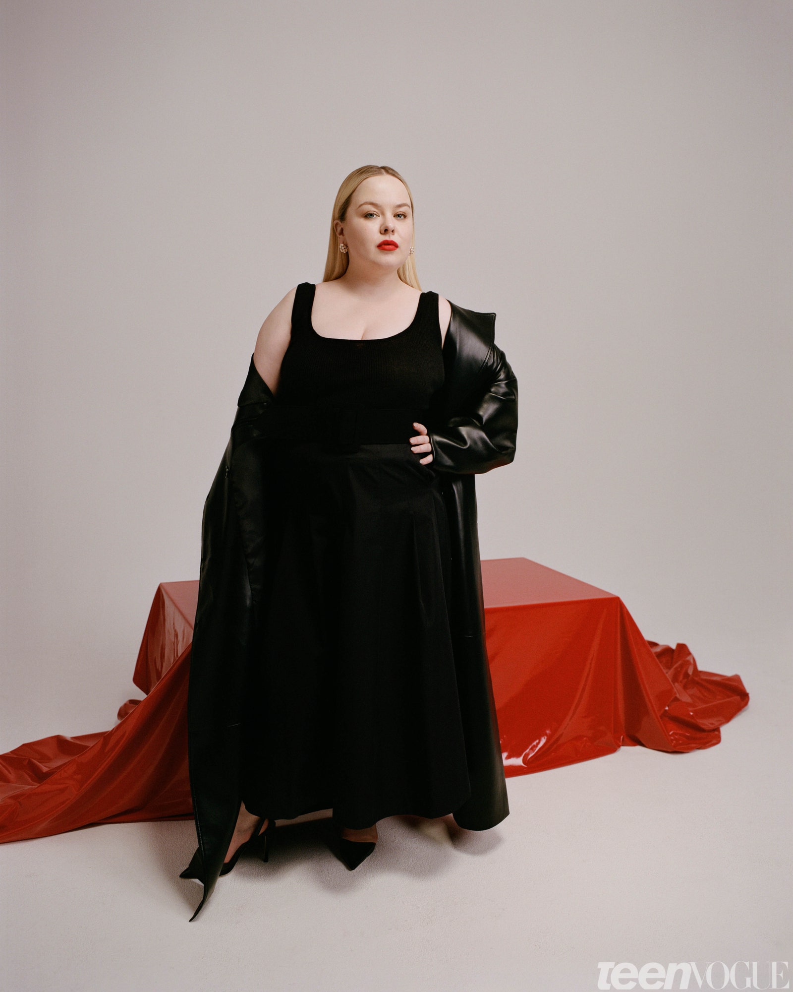Nicola Coughlan in a black dress near red clothed box on the ground