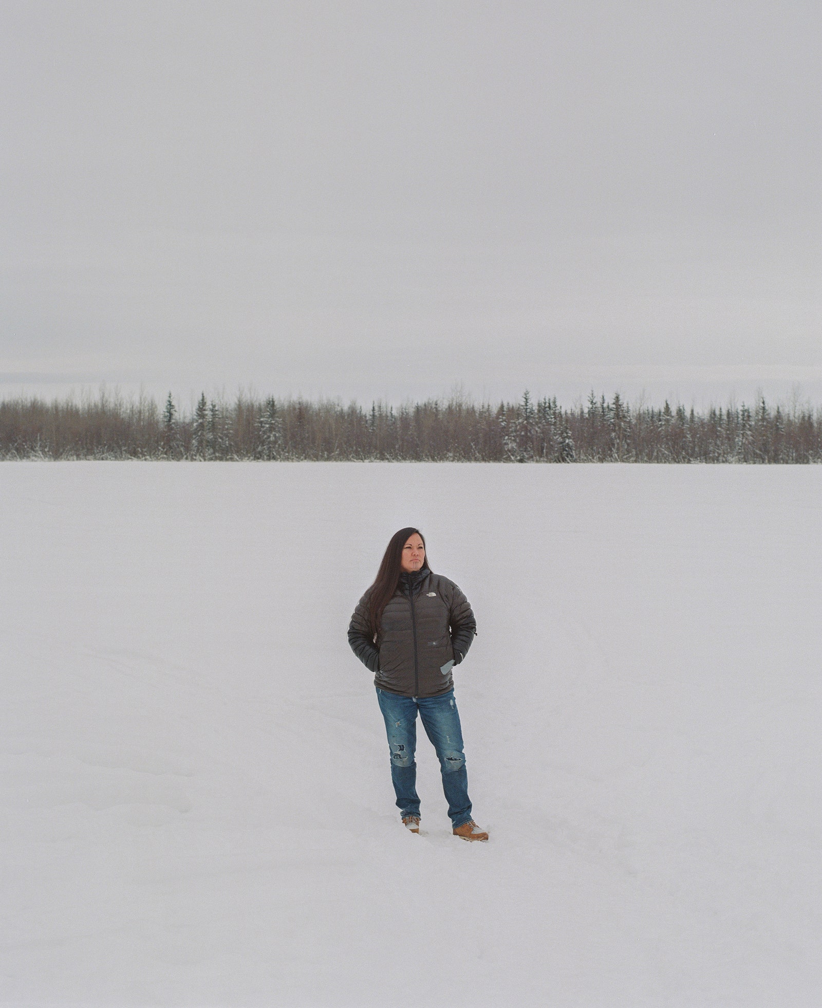 Traditional tattoo artist Jody PottsJoseph stands on the Tanana River.