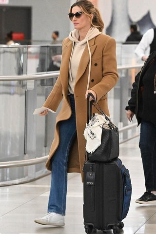 Image may contain Gisele Bündchen Clothing Coat Overcoat Person Adult and Baggage